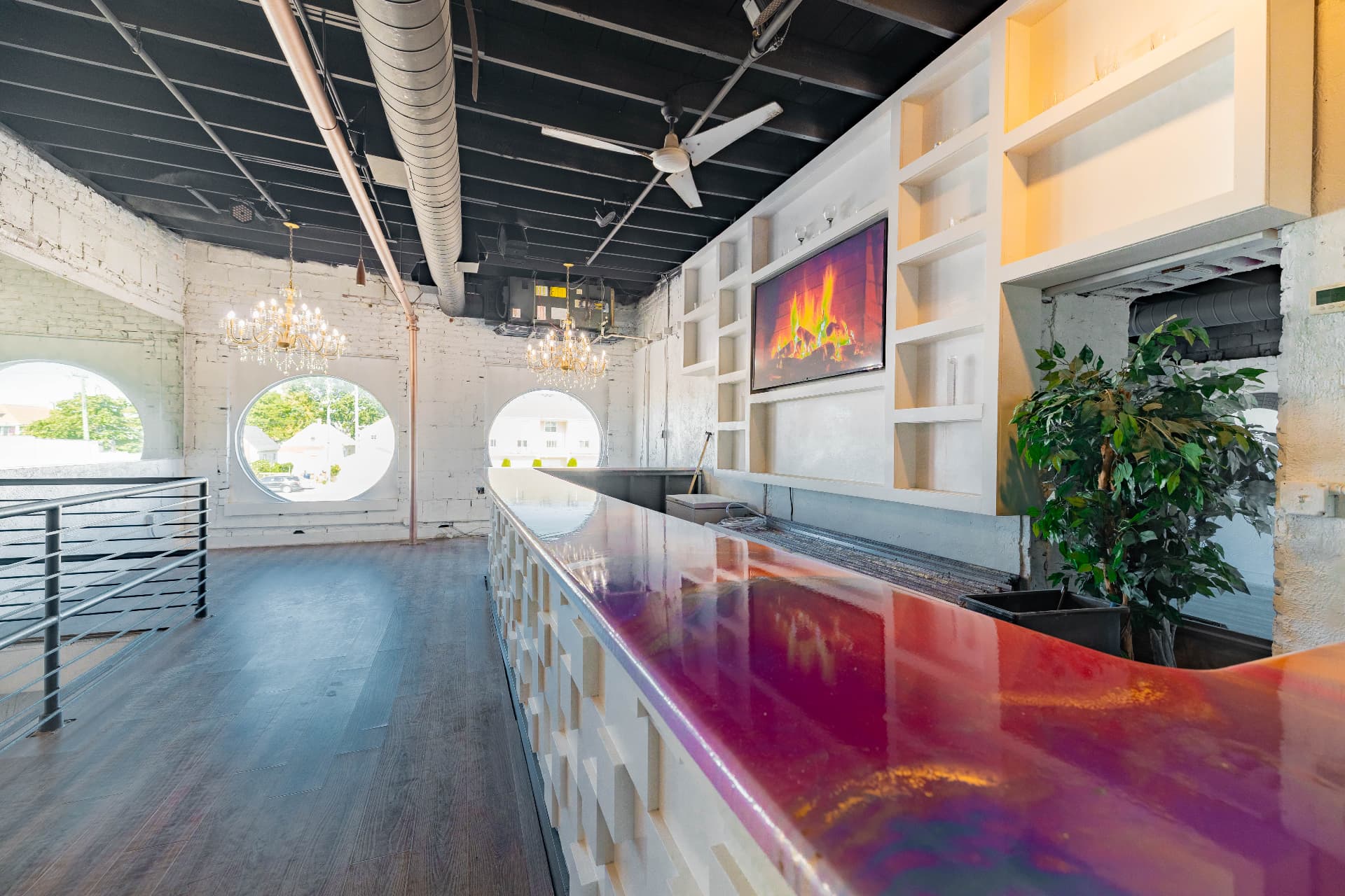 Mezzanine bar room empty, with round porthole windows and chandeliers