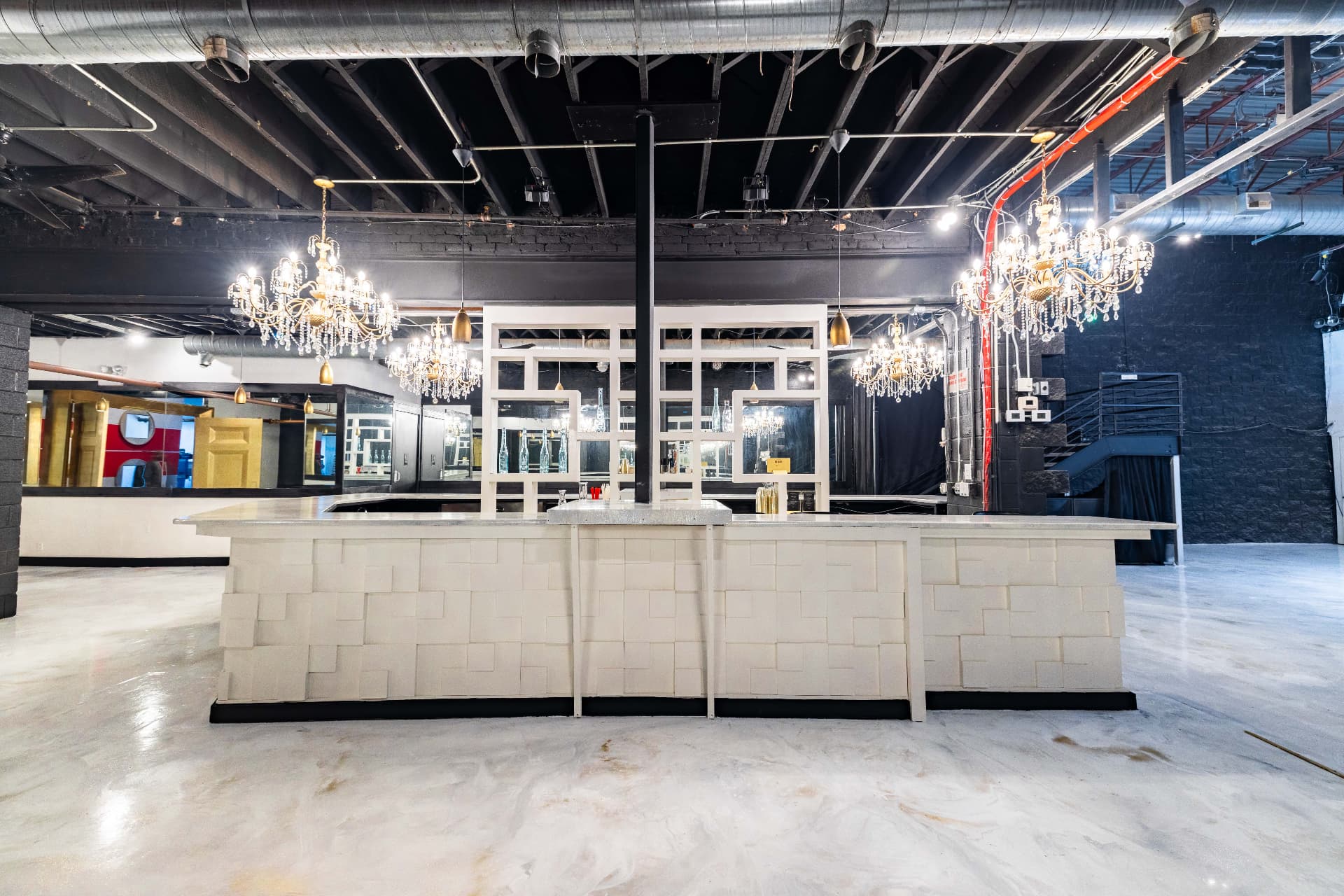 The white block bar and chandeliers with the room empty